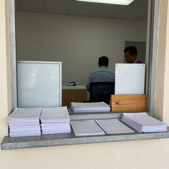 A county permit counter window with printed forms on the ledge.