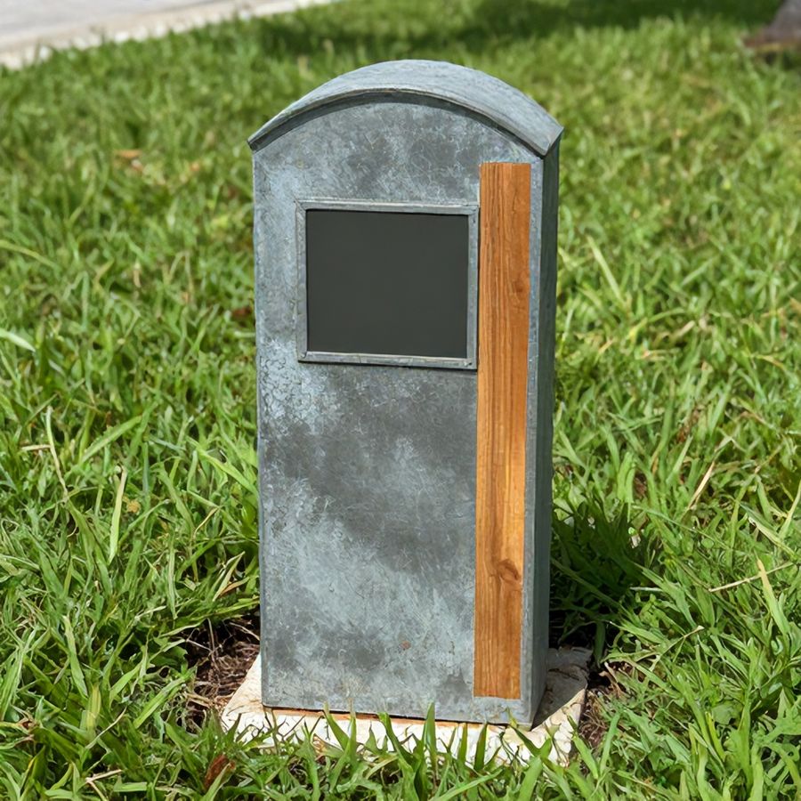 A capped survey monument marking a property corner between two lawns